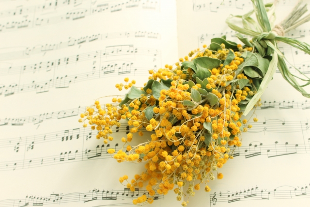 春のピアノ体験レッスンをイメージしたミモザと楽譜の風景
